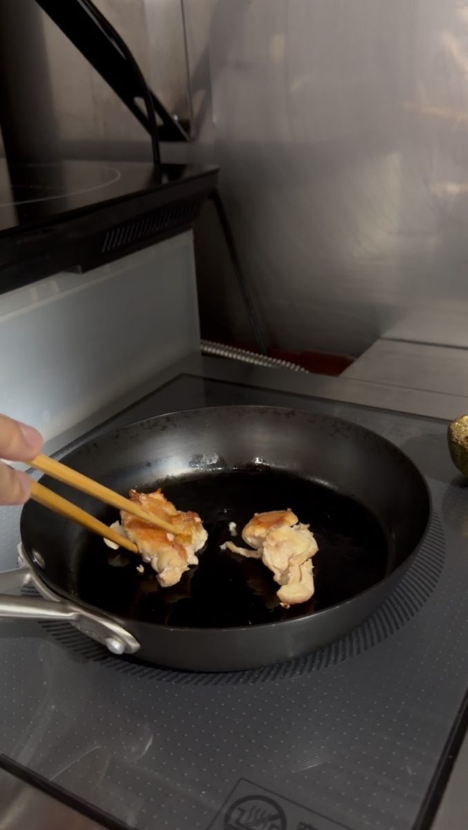 フライパンで照り焼きチキンを焼く様子